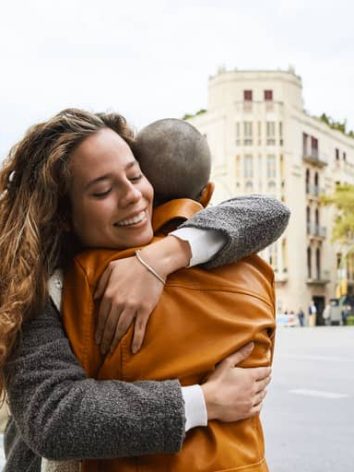 friends-couple-hugging-outside-in-city-during-fall-winter